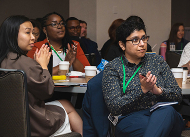 Audience members clap at Policy Action Institute 2024